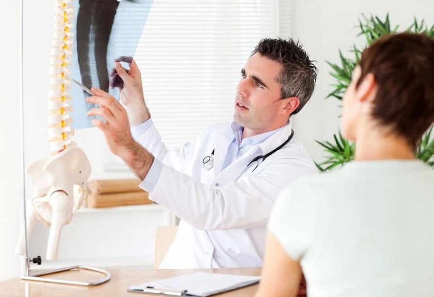 doctor examines an x-ray to diagnose thoracic osteochondrosis